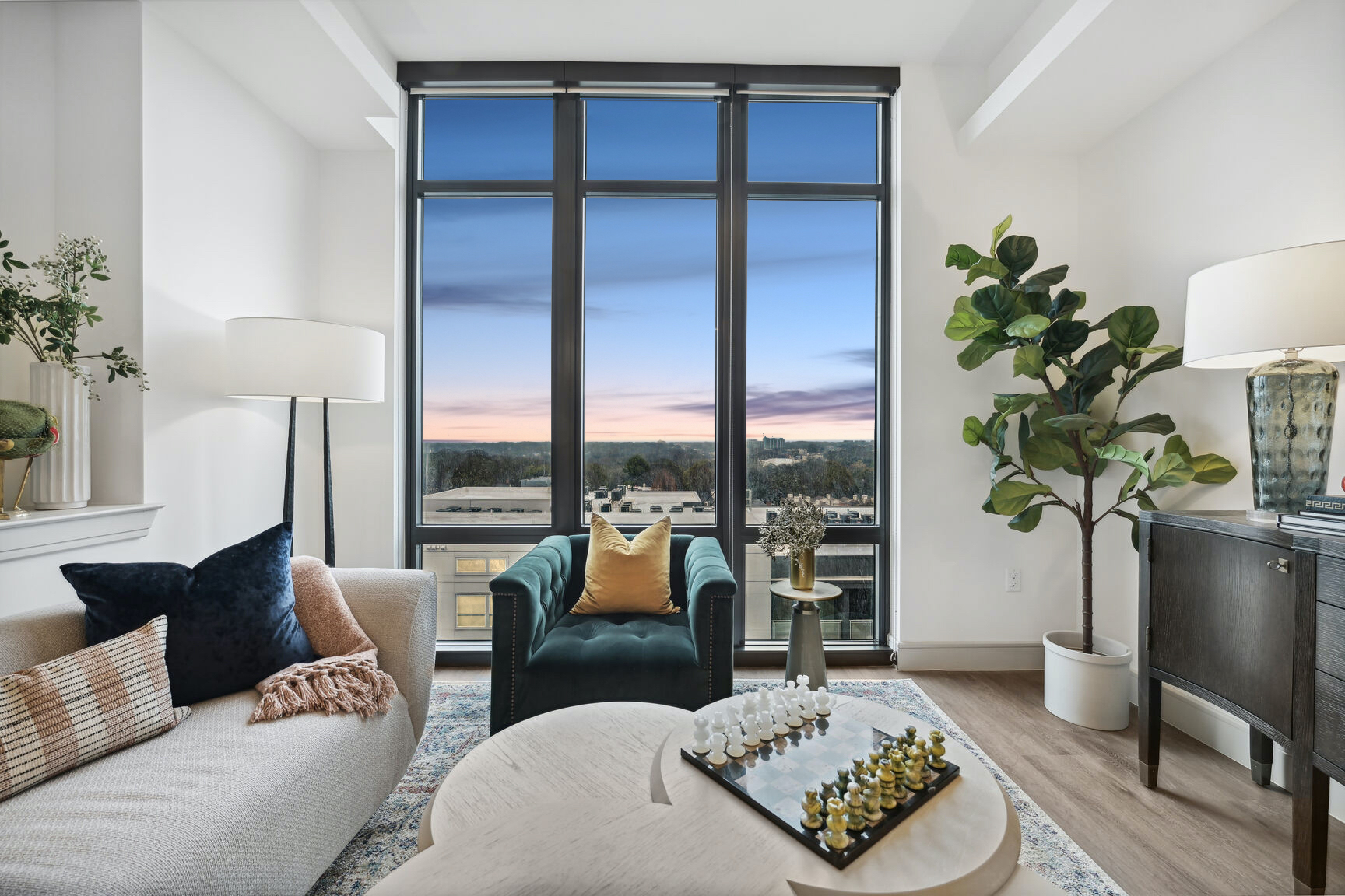 Living Room with floor to ceiling windows at sunset overlooking Atlanta at The Hadley
